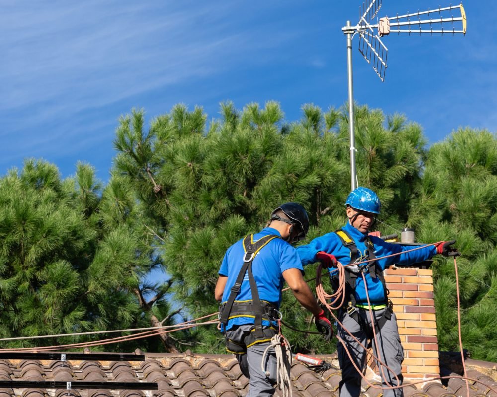 Solar panel installers installing solar panels on the roof of a house